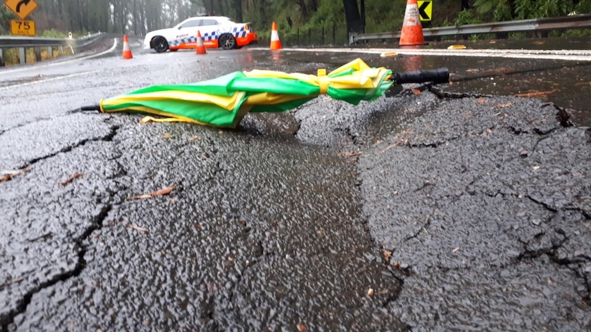 An umbrella lying over a depression in the road.