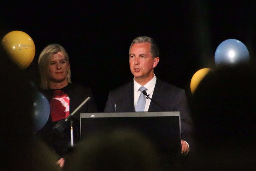 Jeremy Hanson speaks at a podium in front of Liberal Party faithful.