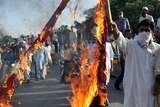 Pakistani Muslim demonstrators burn a US flag as they attempt to reach the US embassy in Islamabad.