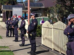 Police stand guard outside a property at Bass Hill