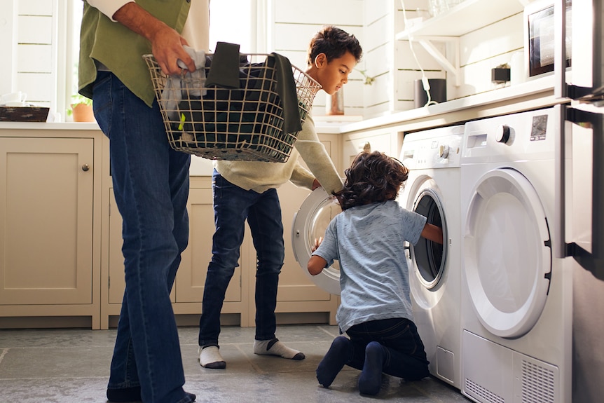 Dad and two sons doing laundry