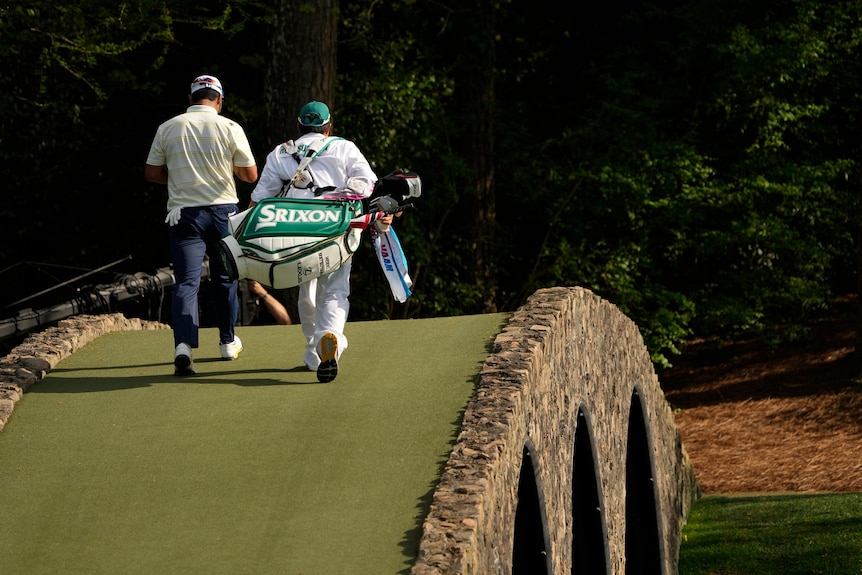 Hideki Matsuyama et son caddie marchent sur le pont Hogan