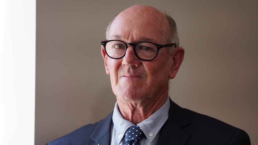 A man wearing glasses and a suit and tie.