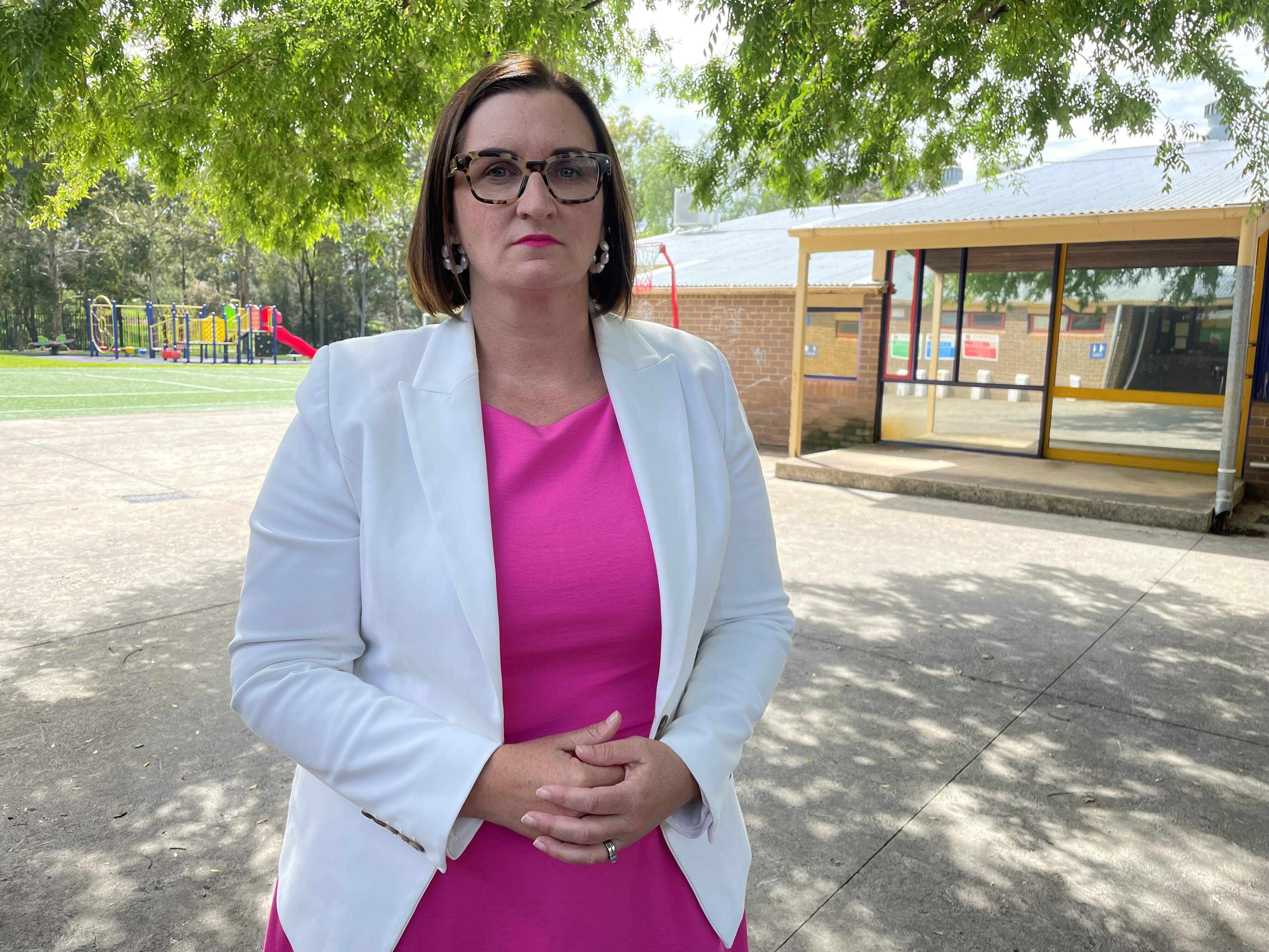 A woman wearing glasses and a white jacket