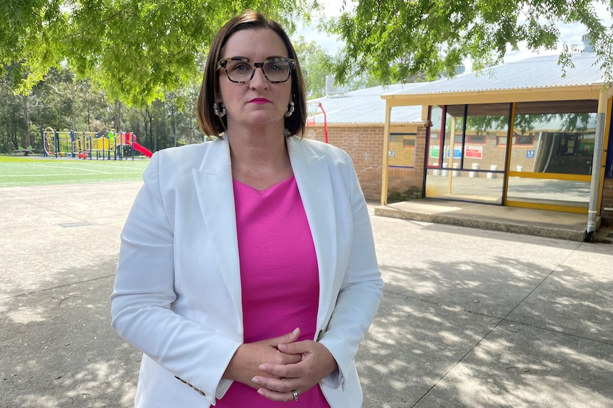 A woman wearing glasses and a white jacket