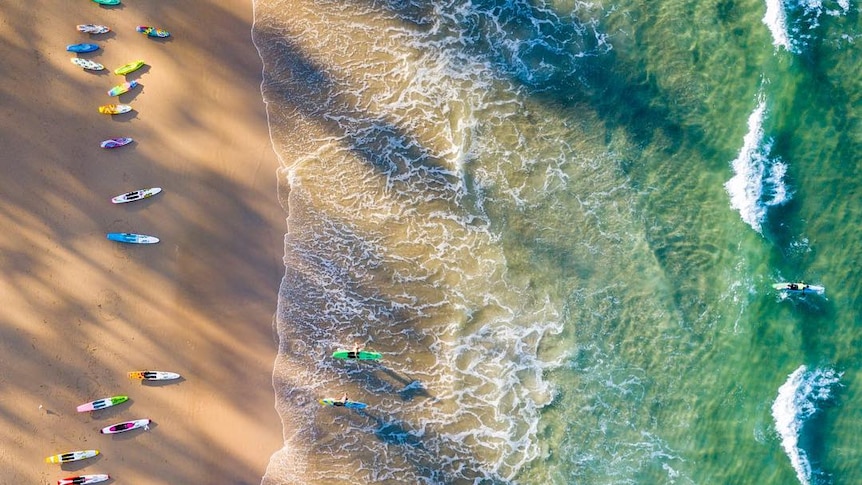 Drone over beach with surf skis on sand