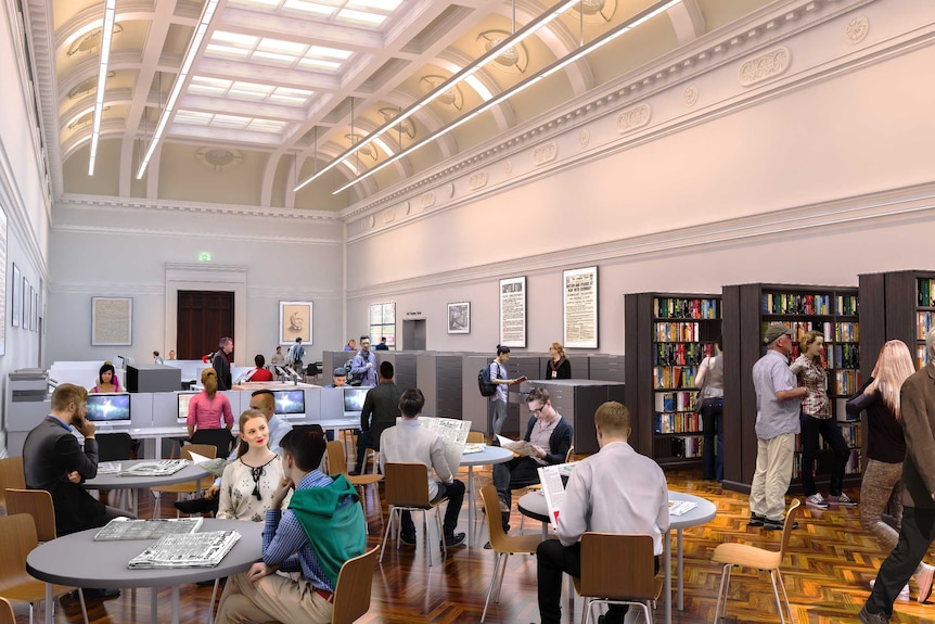 People sit at round desks reading newspapers, as others sit and computers and look at book shelves in the background.