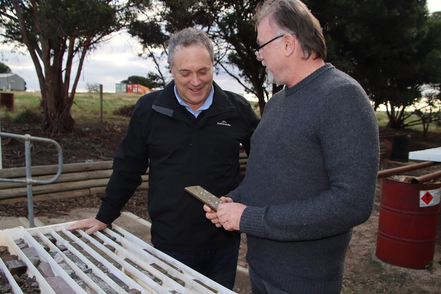 Two men speaking to each other on a farm.