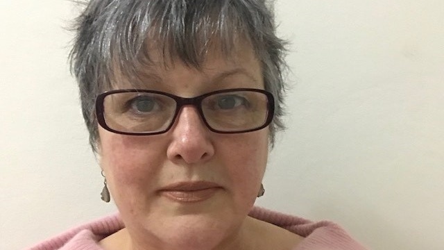 Women aged in her 50s looks straight at the camera