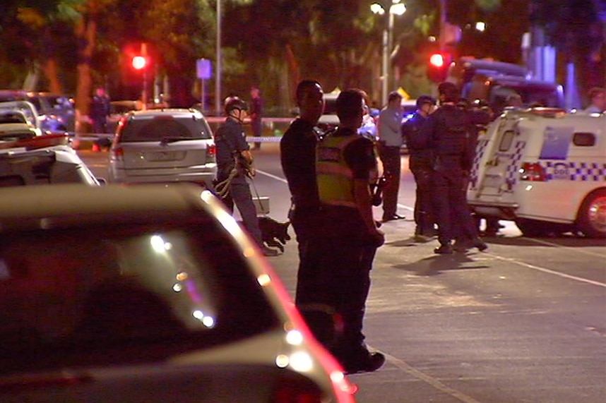 Police officers and a police dog at the scene of a shooting.