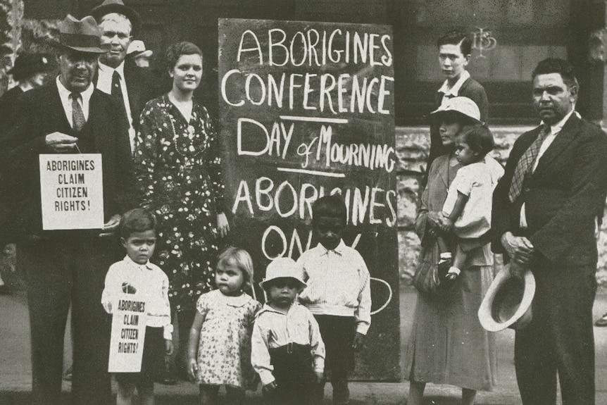 A black and white photo of a large blackboard reading "Day of mourning" outside a hall in Sydney.