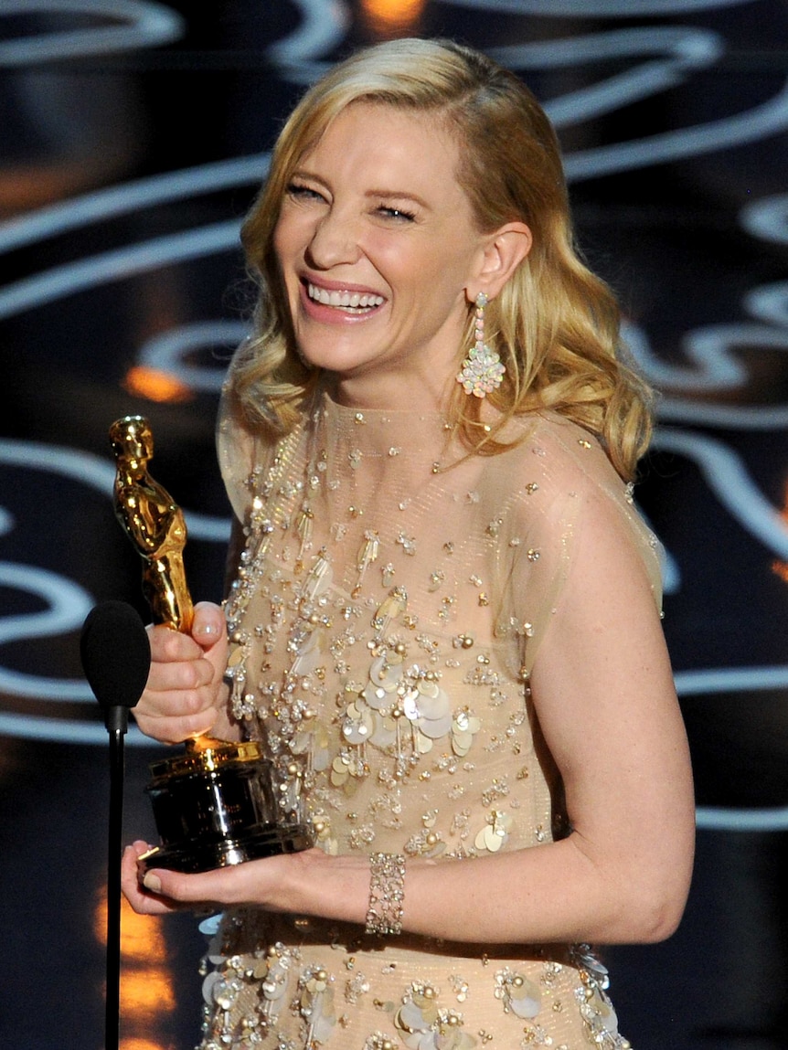 Cate Blanchett holds her Oscar for supporting actress for her role