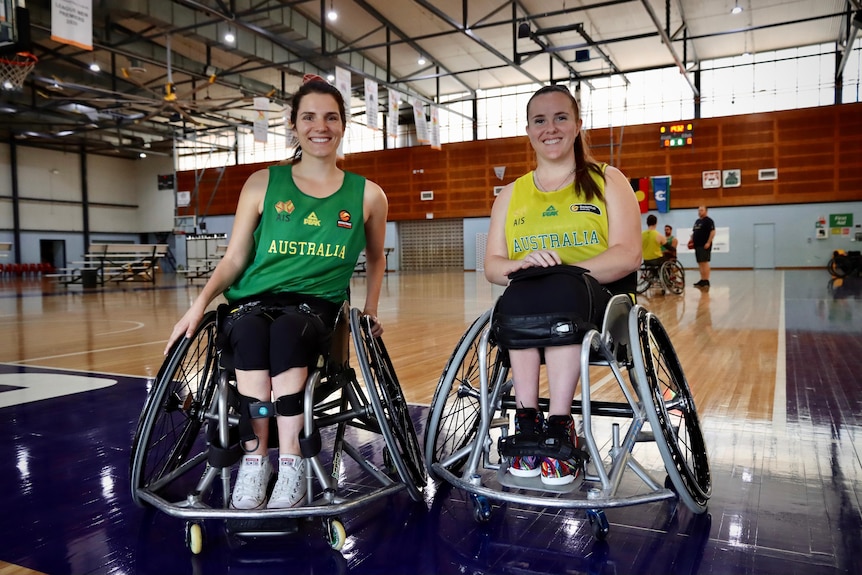 Dos mujeres en sillas de ruedas sonríen a la cámara.