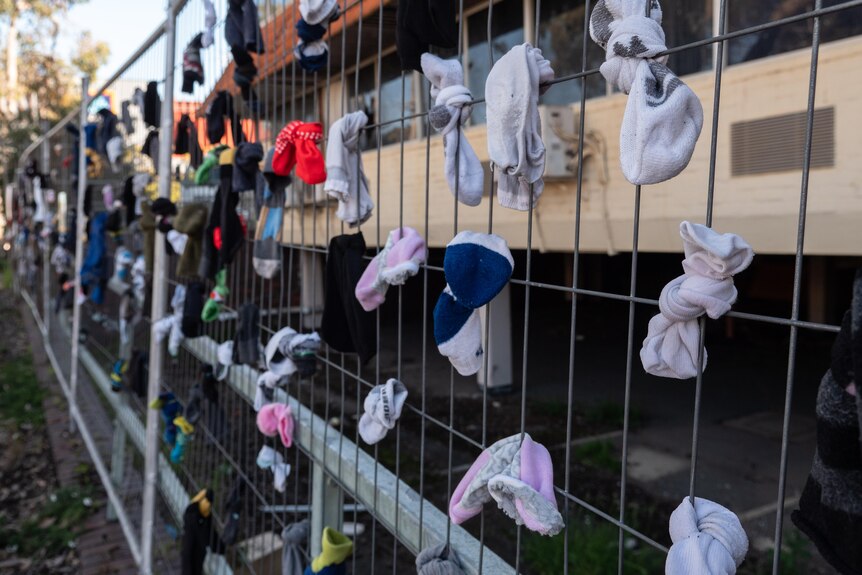 Socks tied to the security fencing to bring attention to its derelict state.