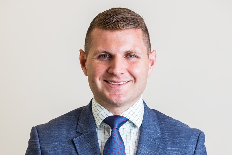 A profile of a man wearing a blue suit