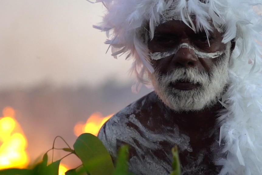 Andrew Gurruwiwi in traditional dress and performing.