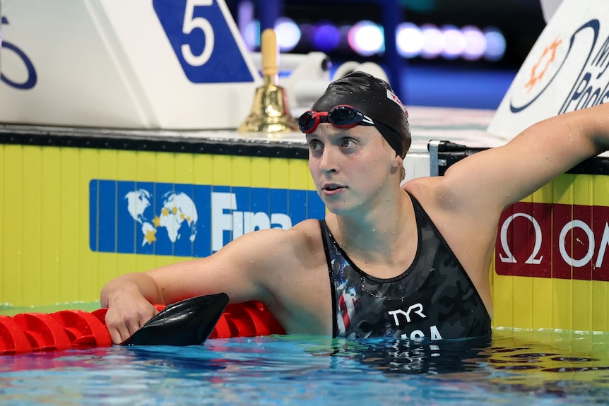 Katie Ledecky regarde la piscine appuyée sur la lanerope