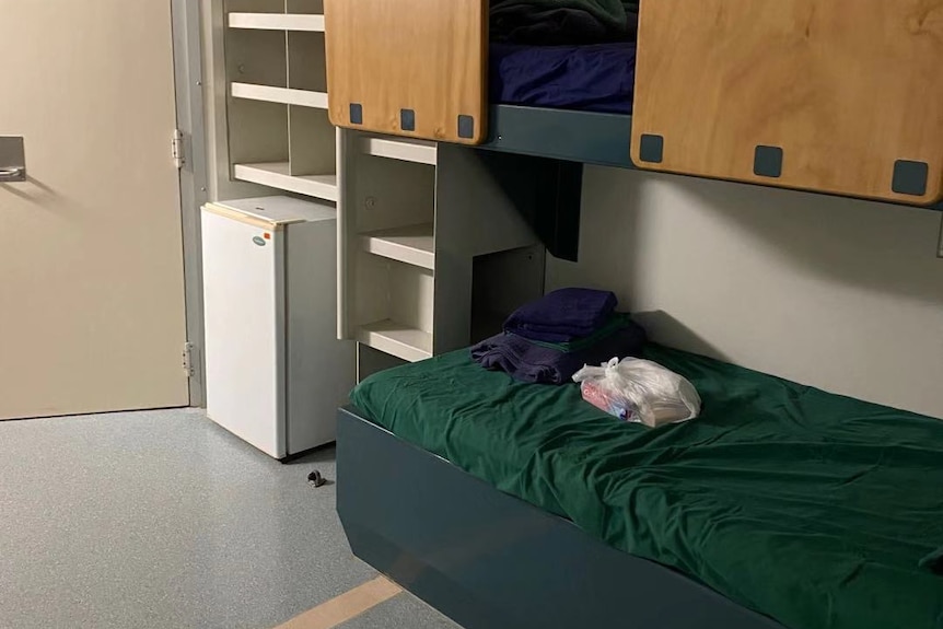 A bunk bed, bar fridge and air conditioner are visible in this photo showing a room for those quarantined on Christmas Island.