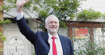 Jeremy Corbyn waves outside his leafy London home.