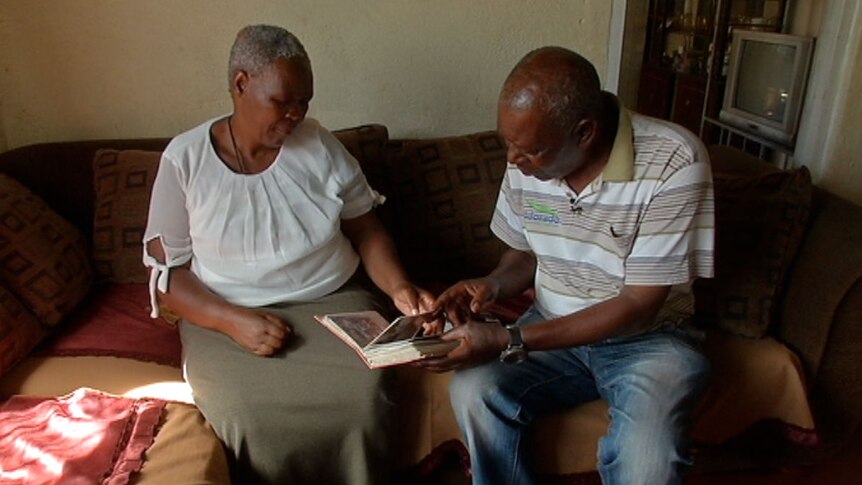Nomvula and Temba Philip Sithole looking at photograph album of their children and grandchildren