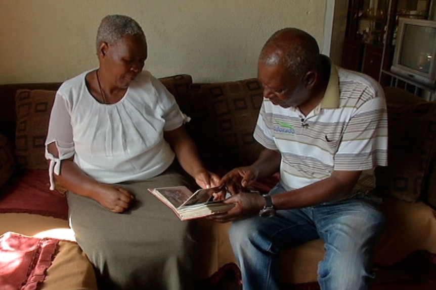 Nomvula and Temba Philip Sithole looking at photograph album of their children and grandchildren