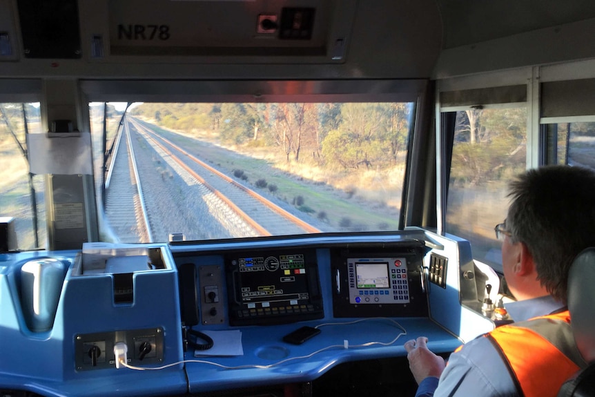 The view from inside the cab of a freight train.