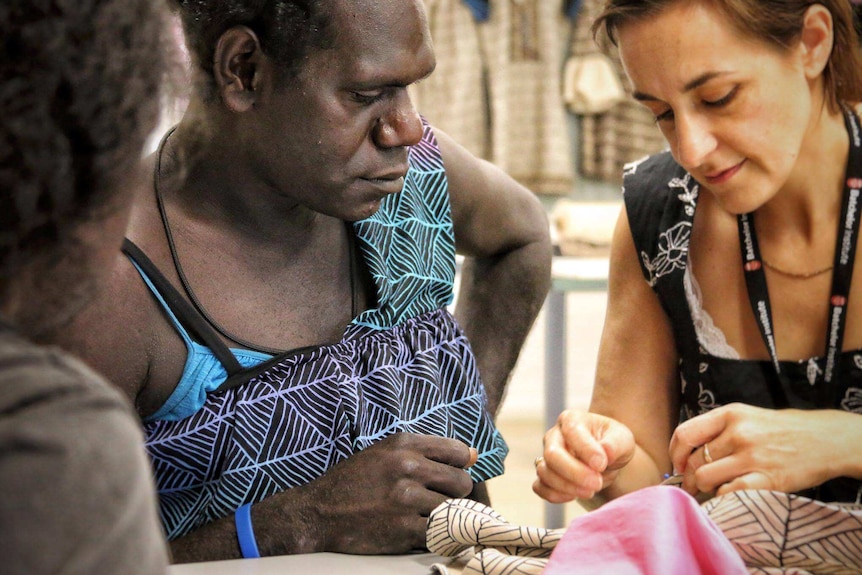 Teacher Brigida Stewart (right) shows Jamie Timaepatua how to pin a dress.