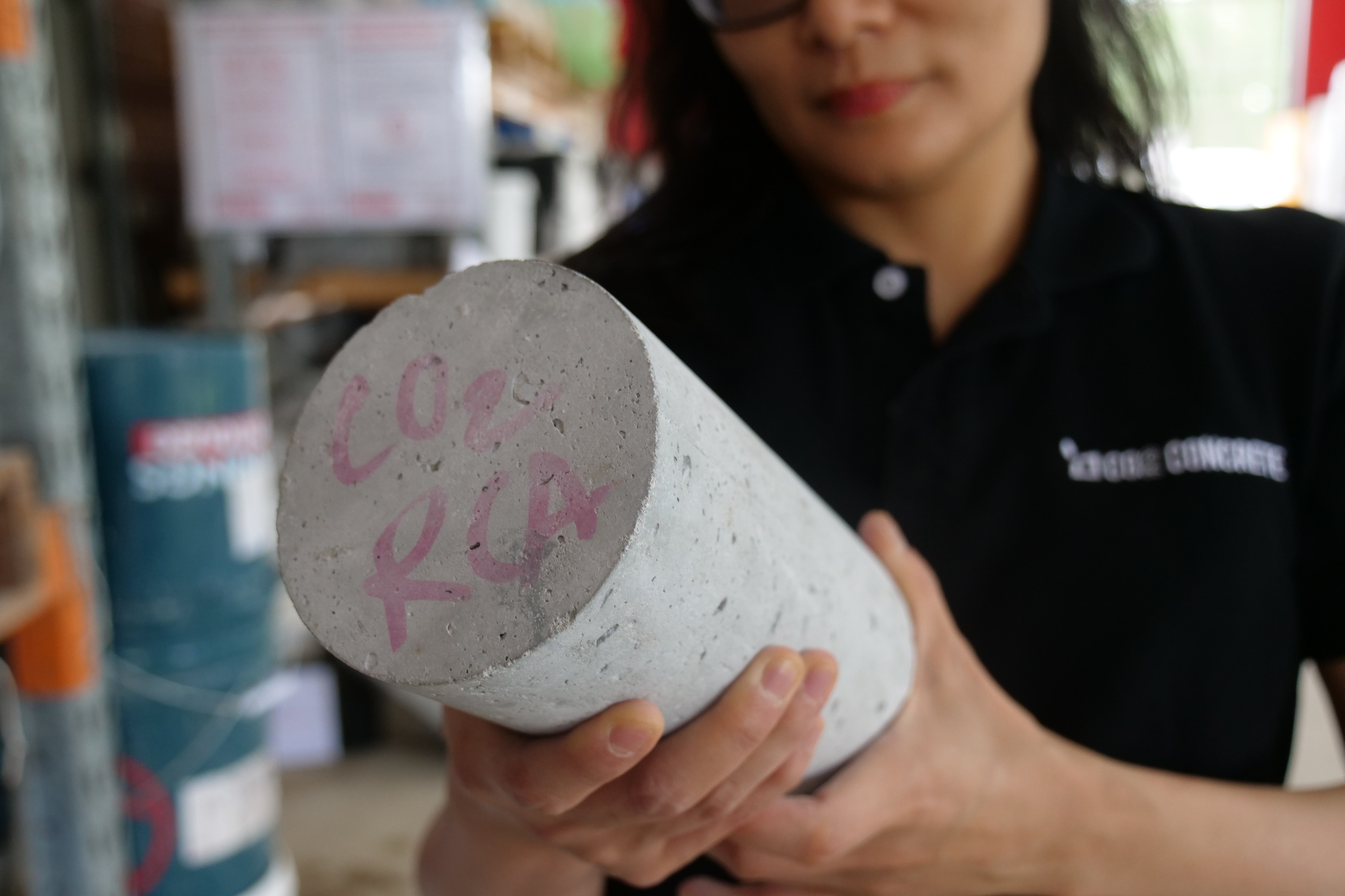 A woman holds a concrete cylinder in her hands