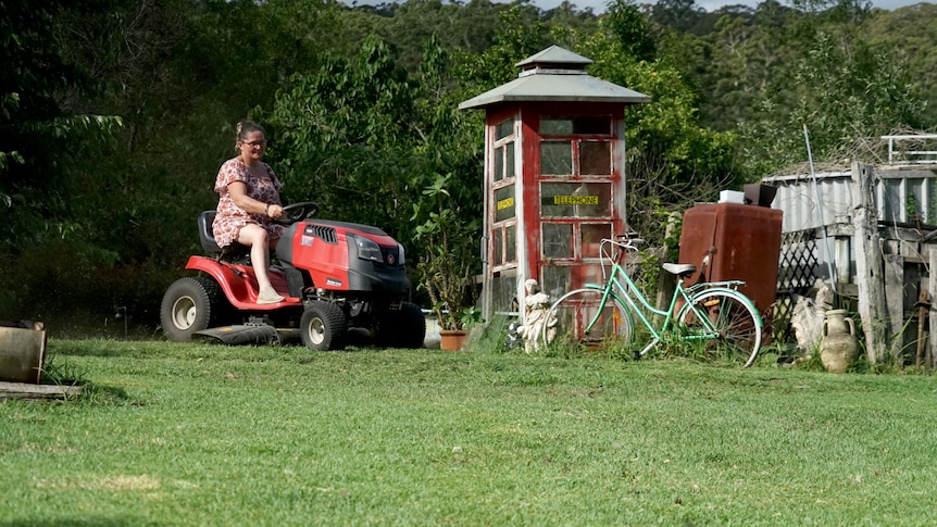 A woman on a ride-on mower.