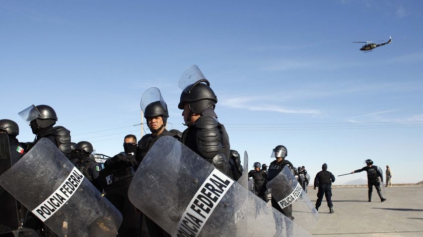 Mexican riot police wait for orders to enter a riot at the state prison