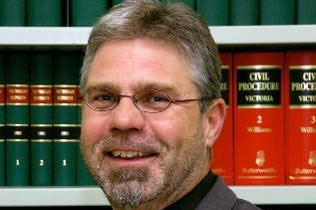 Richard Pithouse sitting in a law office in front of legal books.