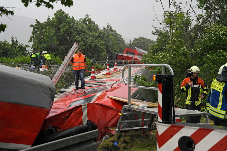 Emergency and rescue forces work on the site of a train crash in Burgrain.