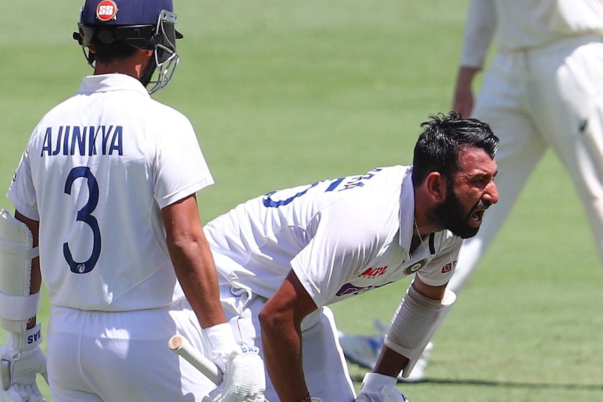 Indian batsman Cheteshwar Pujara screams in pain as teammate Ajinkya Rahane watches on.