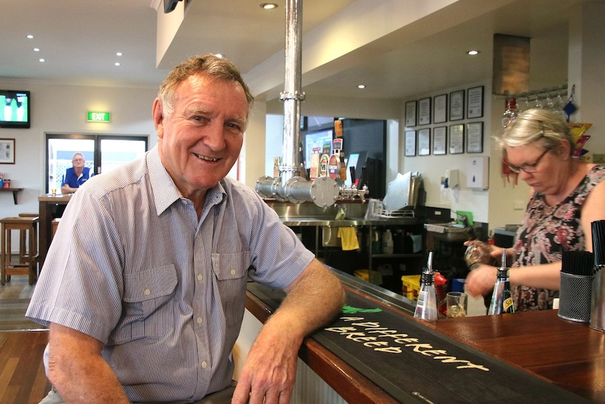 A man at a pub smiling at the camera