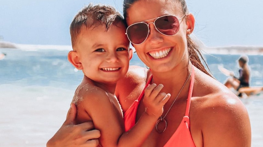 Hannah Clarke, hugs her son Trey Baxter, while standing on a beach.