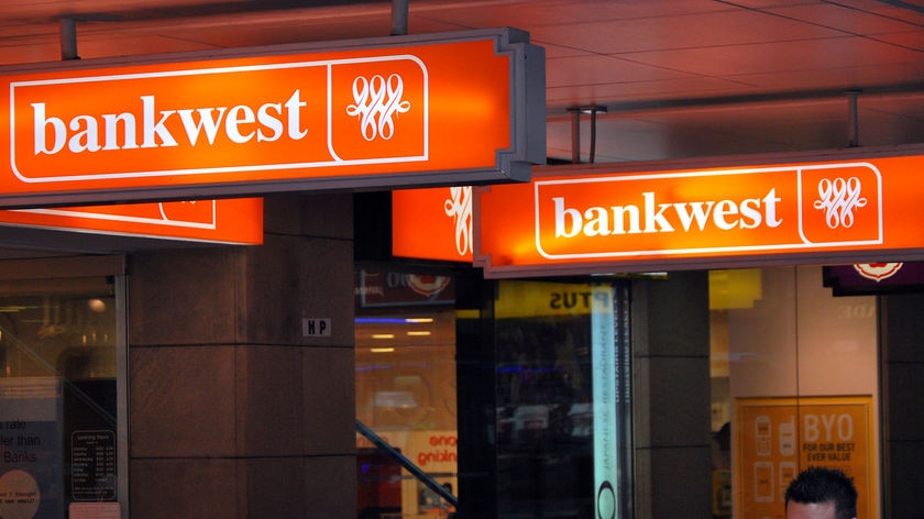 Signs that say "Bankwest" protruding from a shopfront.