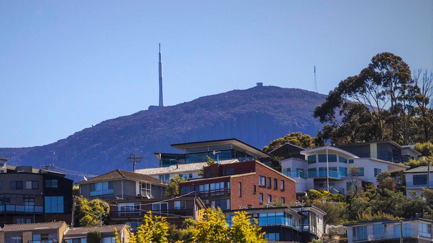 Housing in foreground, with mountain backdrop.