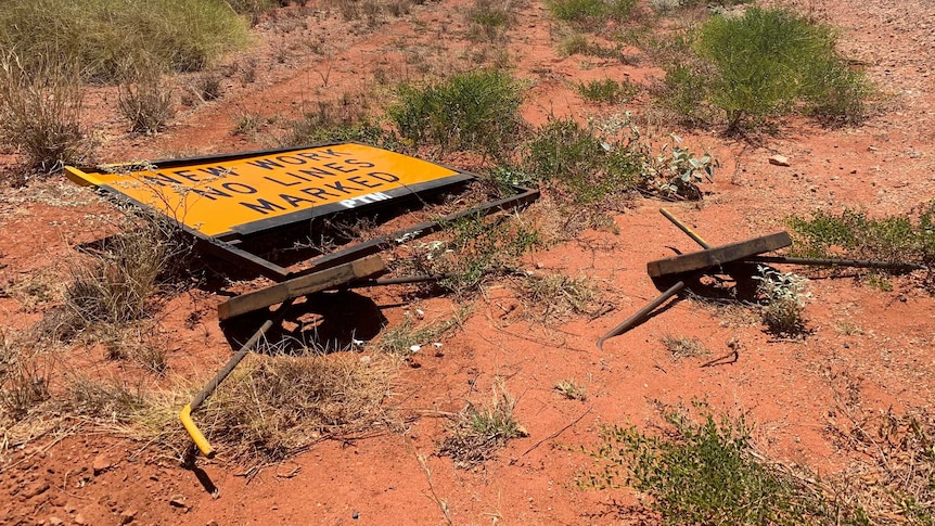 Damaged road sign beside an outback highway