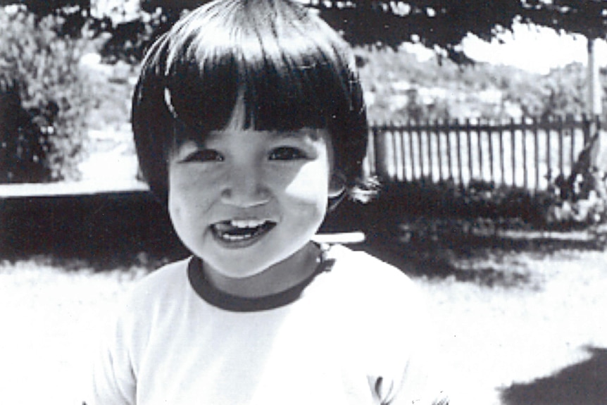 A black and white photograph of a young girl smiling.