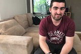 23-year-old Rhys sits on the couch