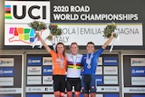 Three women standing on a podium, with medals around their necks and smiling after placing top three in cycling race 
