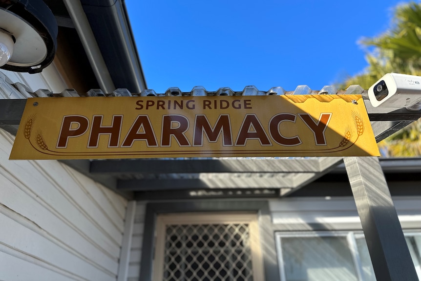A yellow sign which says Spring Ridge Pharmacy.