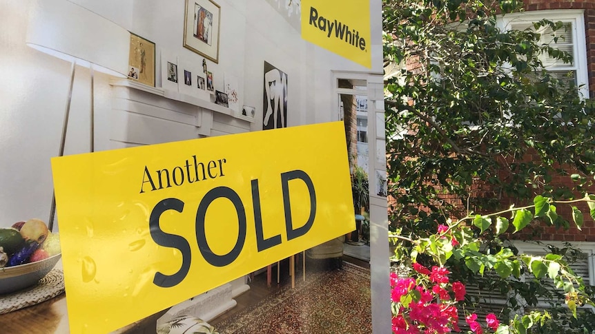 A Ray White sold sign outside a home.