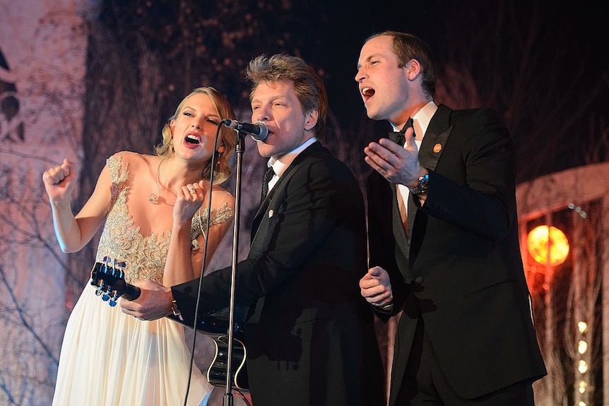 Taylor Swift, Jon Bon Jovi and Prince William singing into a microphone in formal attire. 