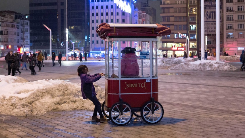 Children play in a chestnut roasting cart in Taksim Square near Gezi park. Once a tourist hub it's now quiet.