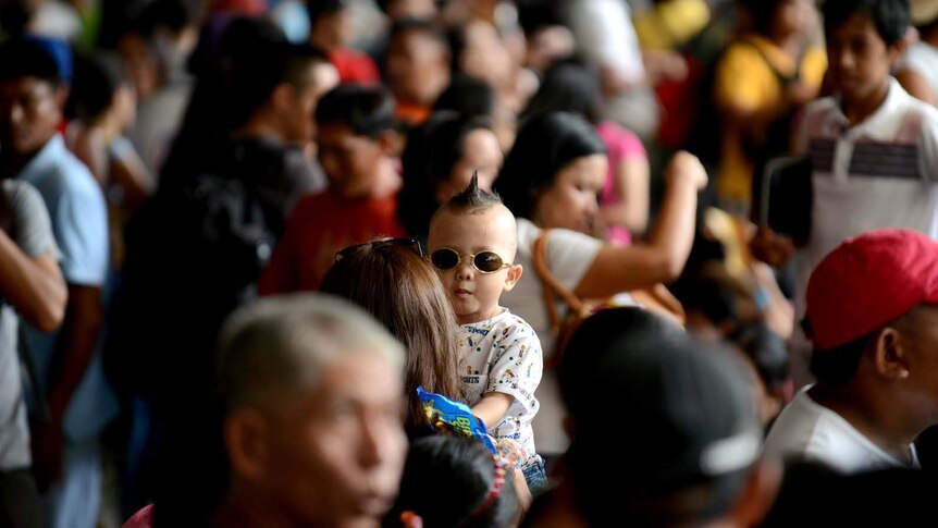 Hundreds of passengers wait for a train in Manila ahead of Easter