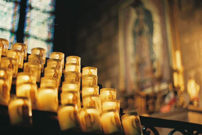 Lit candles inside the Notre Dame cathedral