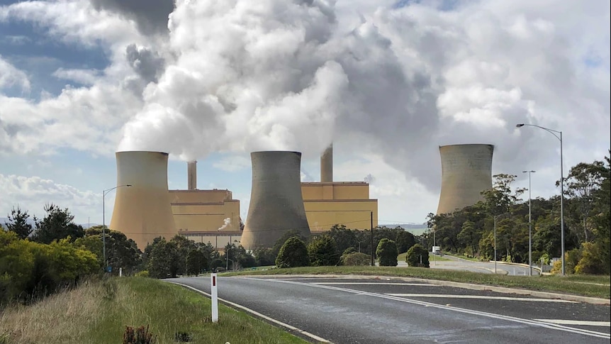 Smoke blowing into sky out of power plants 