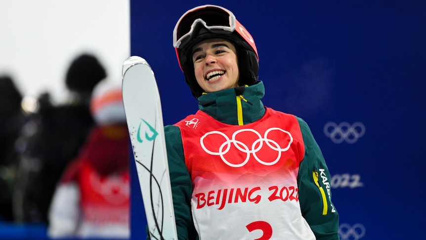 An Australian smiles after winning gold in the women's moguls at the Winter Olympics in Beijing.