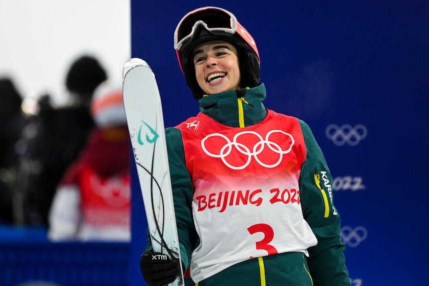 An Australian smiles after winning gold in the women's moguls at the Winter Olympics in Beijing.